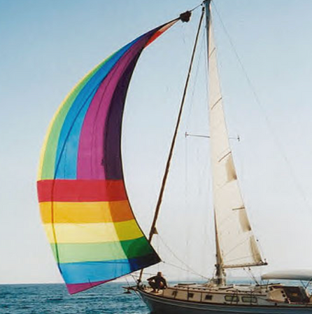 Sail boat with a rainbow patterned sail